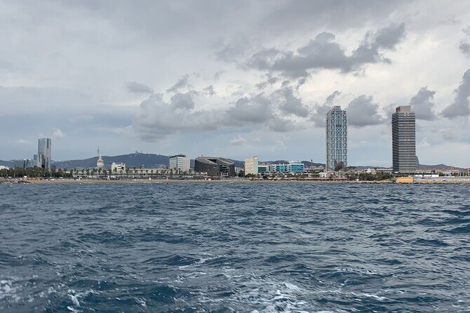 Private sailing and paddlesurfing tour with skipper up to 11 people - Sailing the Barcelona skyline: Sagrada Familia, Montjuïc, and the Agbar Tower